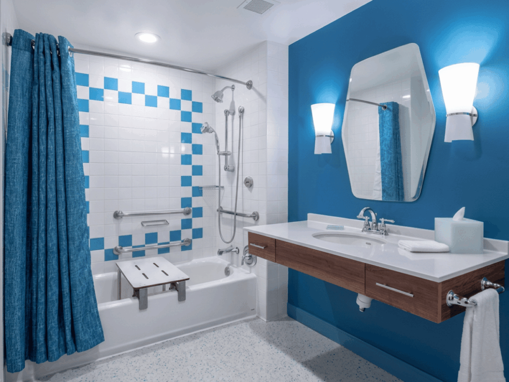 Accessible bathroom with bathtub and blue tiled wall at Cabana Bay