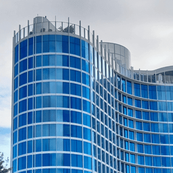 🏖️ Cabana Bay Beach Resort Review with Volcano Bay View – A Fantastic Family Hotel 17 Curved blue-glass tower of Cabana Bay Beach Resort against a cloudy sky