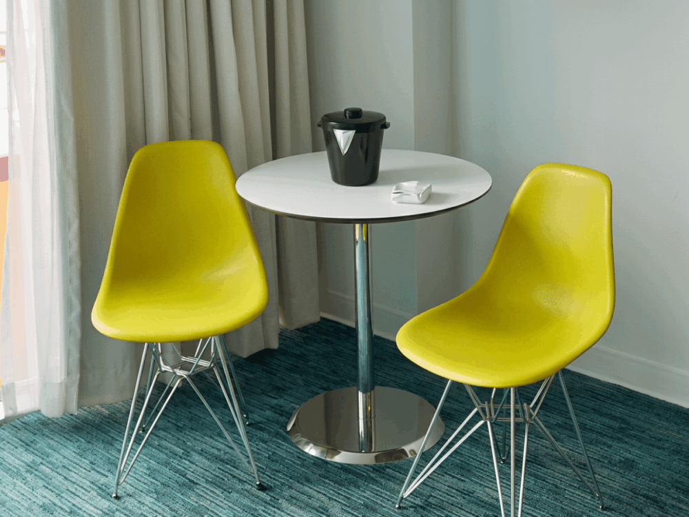 Retro-style table and yellow chairs inside a Cabana Bay room