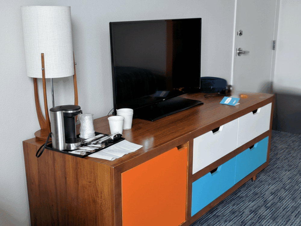 TV, coffee station and colourful storage unit inside a Cabana Bay room