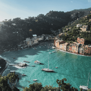 Aerial view of Portofino’s colourful harbour surrounded by lush hills and turquoise waters. Portofino travel guide