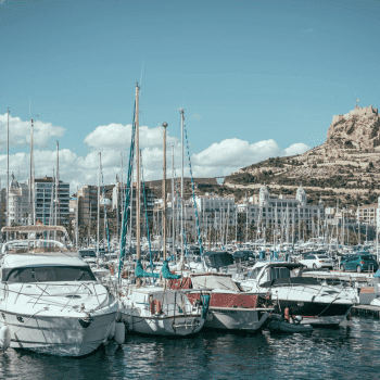 Compare Flights and Travel Essentials 21 Boats and yachts docked at Alicante Marina with Santa Bárbara Castle visible in the background