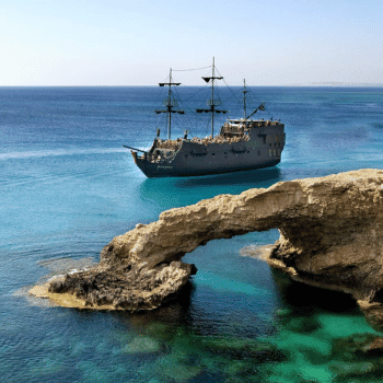Ayia Napa in May – A Mum & Daughter Escape 🌊☀️ 52 Pirate-style ship sailing in turquoise waters near a natural rock arch in Ayia Napa