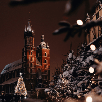 Compare Flights and Travel Essentials 19 St. Mary’s Basilica in Kraków lit up at night with snow-covered Christmas trees and festive lights