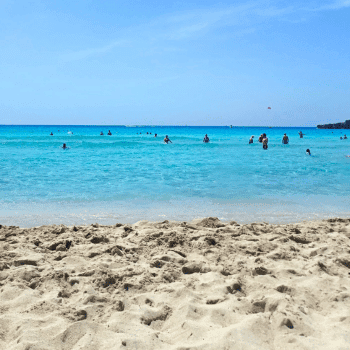Ayia Napa in May – A Mum & Daughter Escape 🌊☀️ 28 View from the sandy shore of Nissi Beach, Cyprus, with turquoise waters and people swimming in the sea.