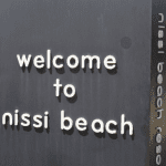 Ayia Napa in May – A Mum & Daughter Escape 🌊☀️ 2 Black sign with white letters reading “welcome to nissi beach”
