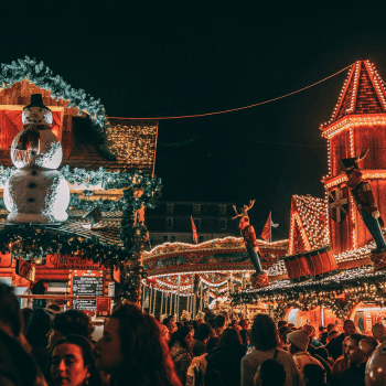 Compare Flights and Travel Essentials 20 Crowds enjoying a Christmas Market with colourful stalls and holiday lights