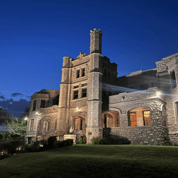 🎃 Spooky Season Travel Deals & Haunted Adventures ✈️👻 18 Pythian Castle in Springfield, Missouri, illuminated at night against a deep blue sky.