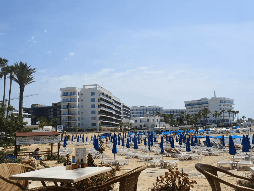 Sandy beach with sun loungers and hotels in Ayia Napa