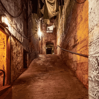 🎃 Spooky Season Travel Deals & Haunted Adventures ✈️👻 21 Historic underground street of The Real Mary King’s Close in Edinburgh, Scotland, dimly lit with warm lights.