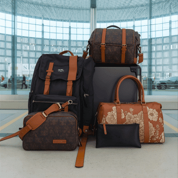 Collection of duffel bags, backpacks, and travel totes in airport setting