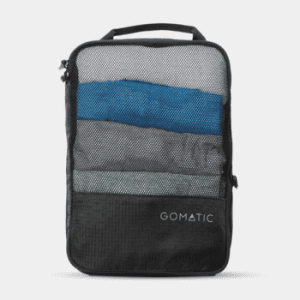 Black Gomatic compression packing cube filled with folded clothes, designed for organised and space-saving travel
