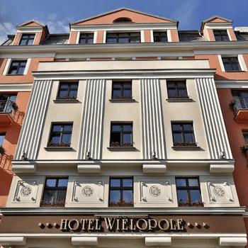 Compare Flights and Travel Essentials 17 Exterior of Hotel Wielopole in Kraków, Poland, with classic architecture and flower-decorated windows.