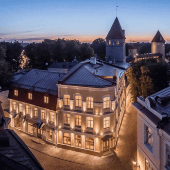 Compare Flights and Travel Essentials 41 Elegant Hotel Telegraaf lit up at dusk in Tallinn’s Old Town, Estonia
