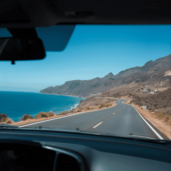 Compare Flights and Travel Essentials 12 View of Tenerife’s coastline from a car driving along a winding ocean road.