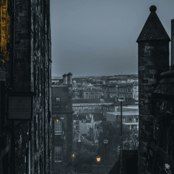 Compare Flights and Travel Essentials 31 View of Edinburgh’s Old Town streets and rooftops at dusk with lanterns glowing.