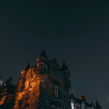 Compare Flights and Travel Essentials 27 Gothic towers of Edinburgh Castle illuminated under a starry night sky.