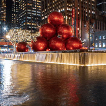 Compare Flights and Travel Essentials 42 Giant red Christmas ornaments on display beside a fountain along Sixth Avenue in New York City