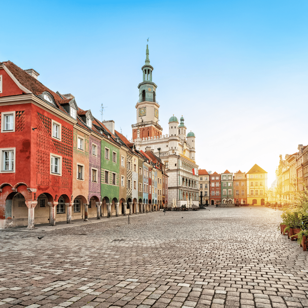 Colourful townhouses and the historic Poznań Town Hall in the Old Market Square at sunrise.