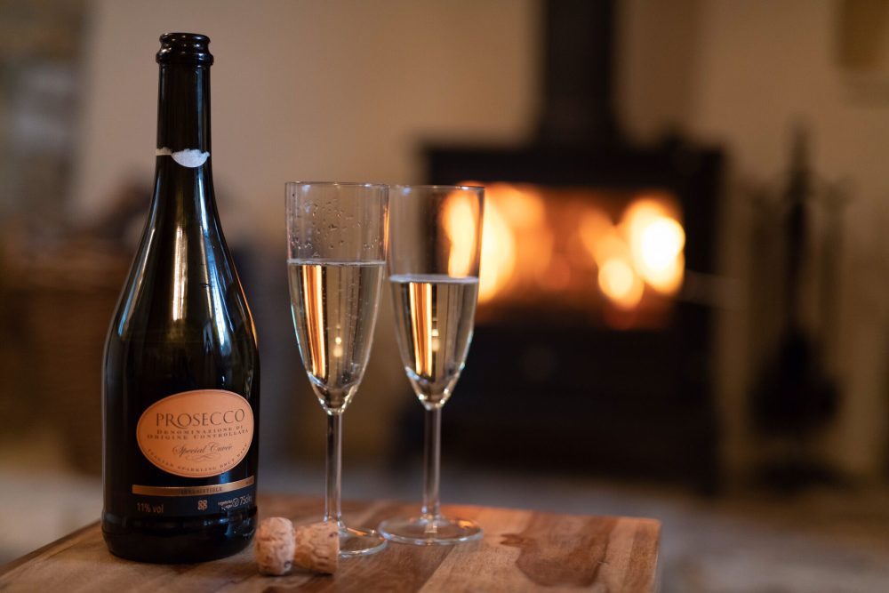 Compare Flights and Travel Essentials 79 Prosecco glasses beside a log burner