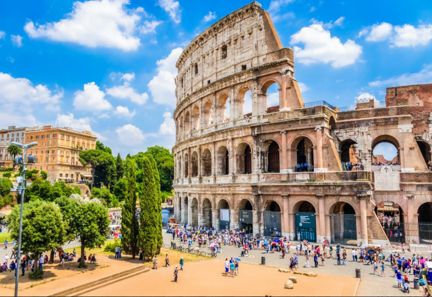 Compare Flights and Travel Essentials 78 The Colosseum in Rome with its ancient stone arches and visitors gathered around the exterior