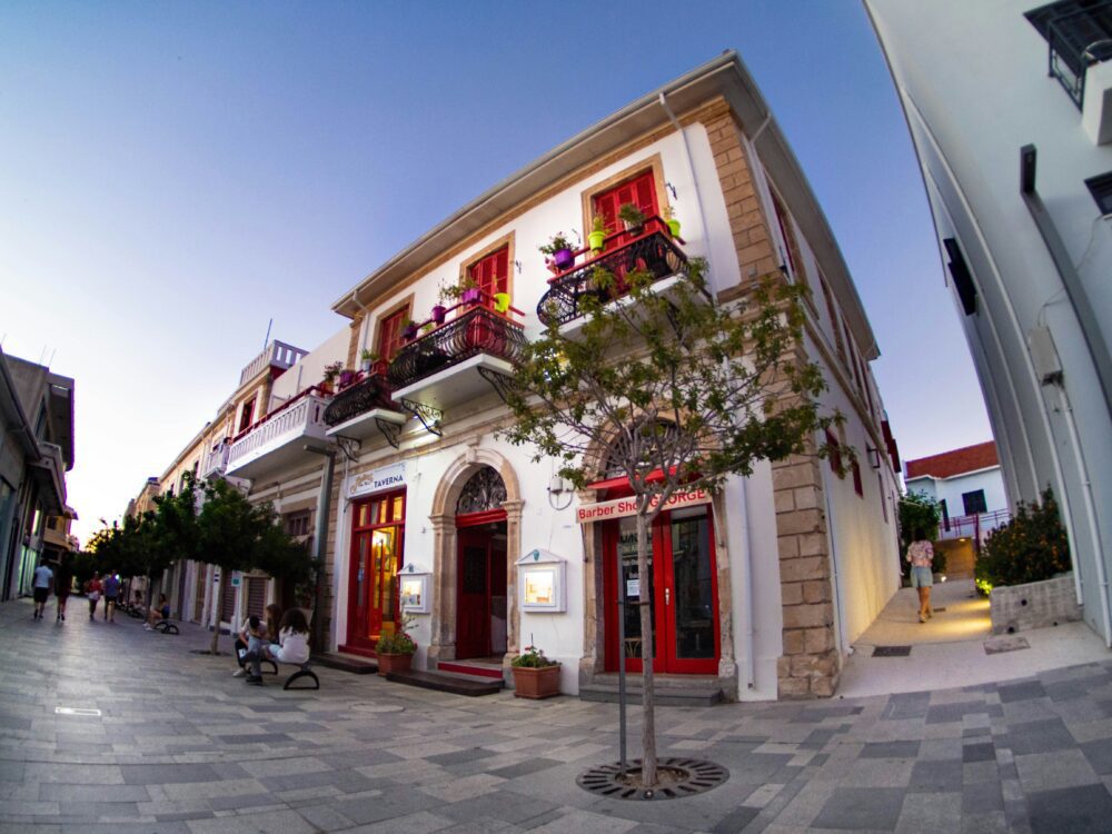 Compare Flights and Travel Essentials 52 Traditional building with red shutters and balconies in a pedestrian street