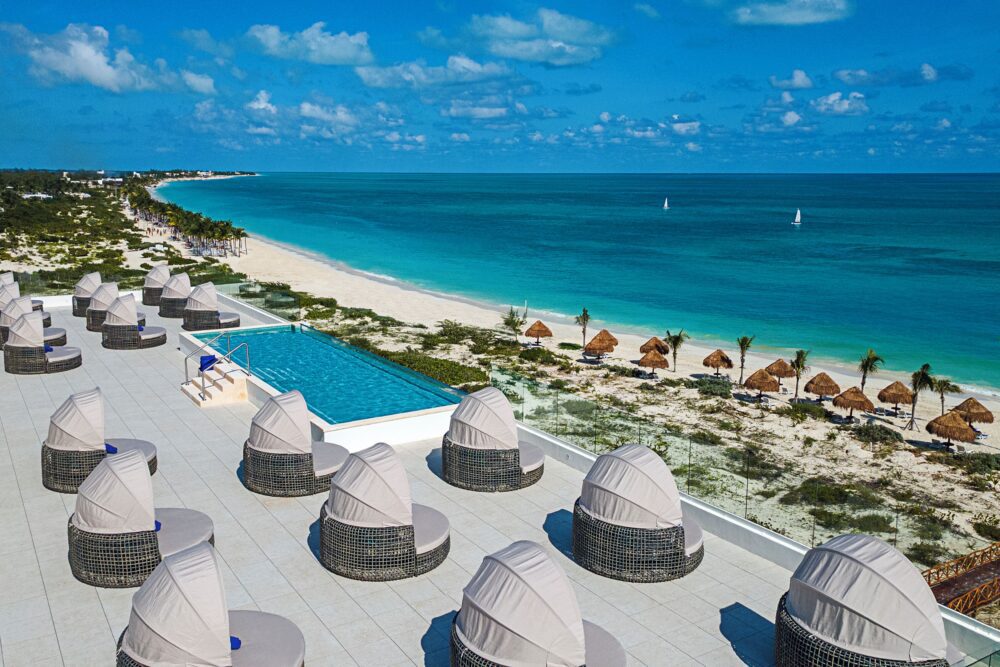Compare Flights and Travel Essentials 35 Rooftop infinity pool overlooking white sand beach and turquoise sea