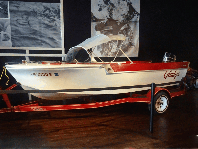 Small red and white boat displayed indoors