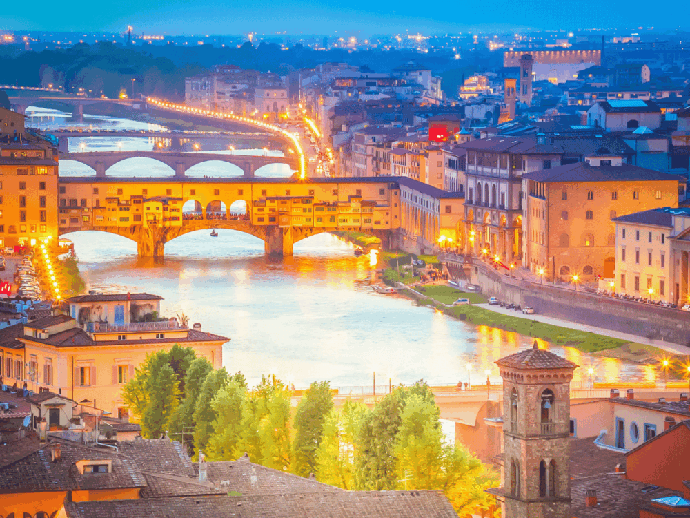 Florence skyline and river bridges illuminated at dusk