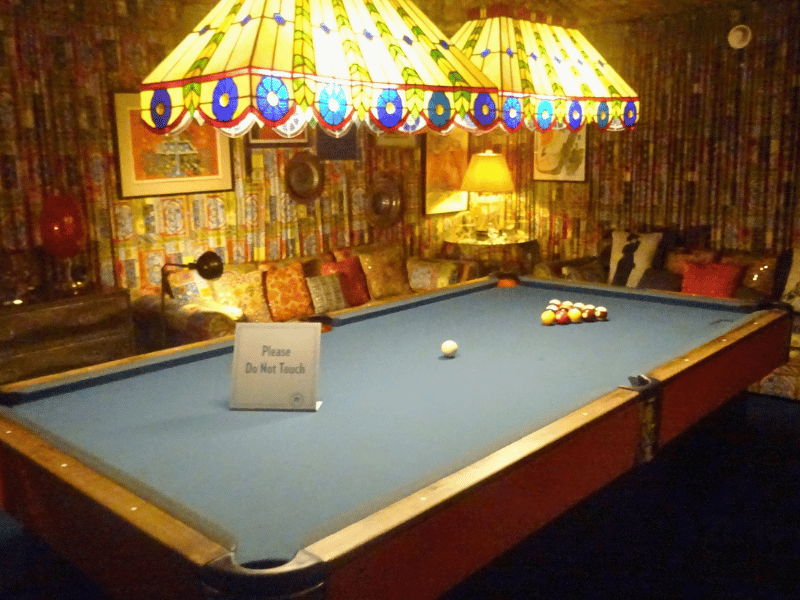Pool table in colourful room with patterned fabric walls