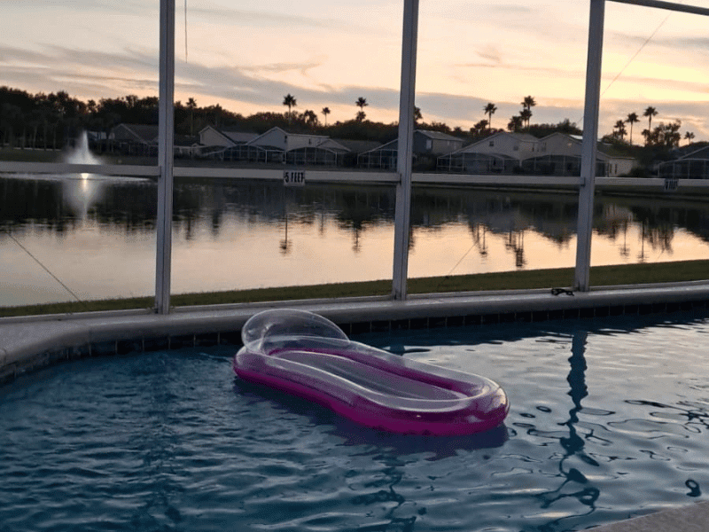 Private villa pool with float overlooking lake at sunset