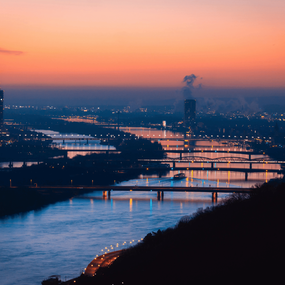 Compare Flights and Travel Essentials 14 Sunset view over Vienna with river bridges and city lights