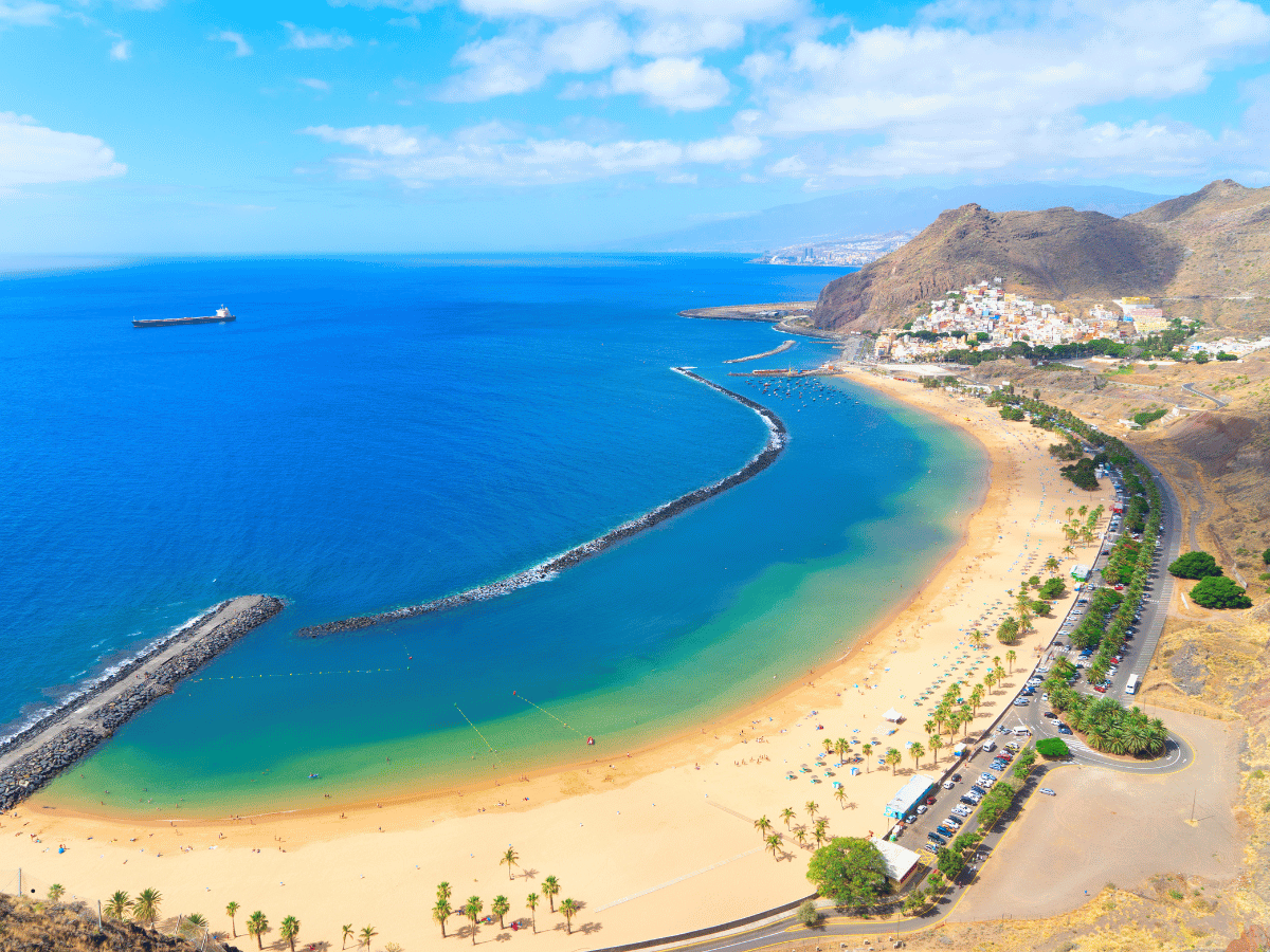 Sandy beach and curved coastline with mountains in Tenerife