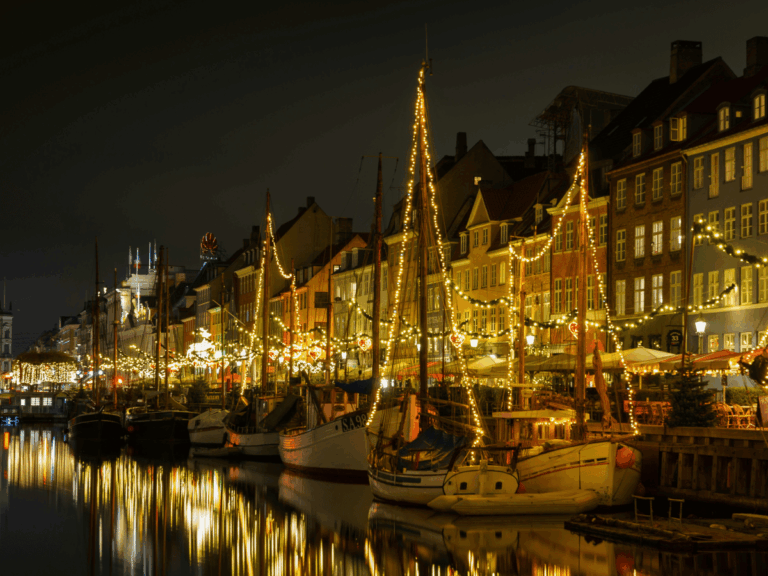 Christmas lights reflecting across Nyhavn Harbour in Copenhagen.