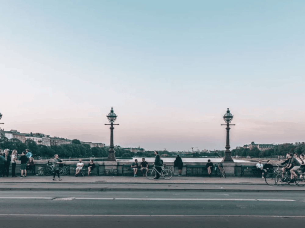 People relaxing and cycling across Dronning Louises Bridge in Copenhagen at sunset.