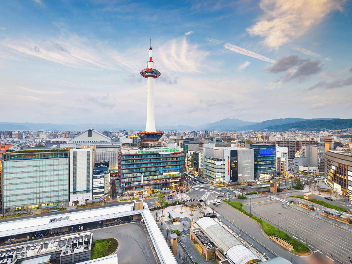 Kyoto Tower rising above the city skyline near Kyoto Station at sunset.