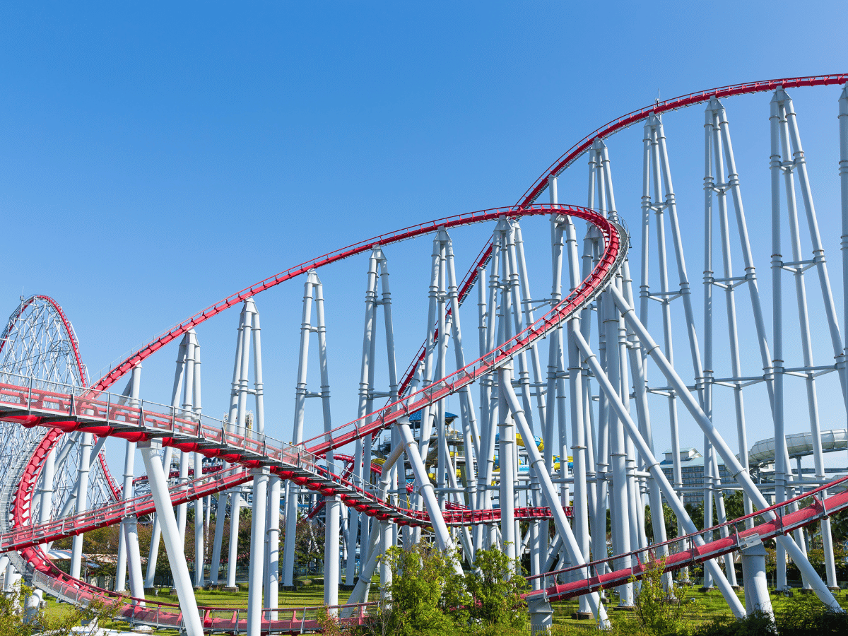 Roller coaster track at a theme park on a sunny day.