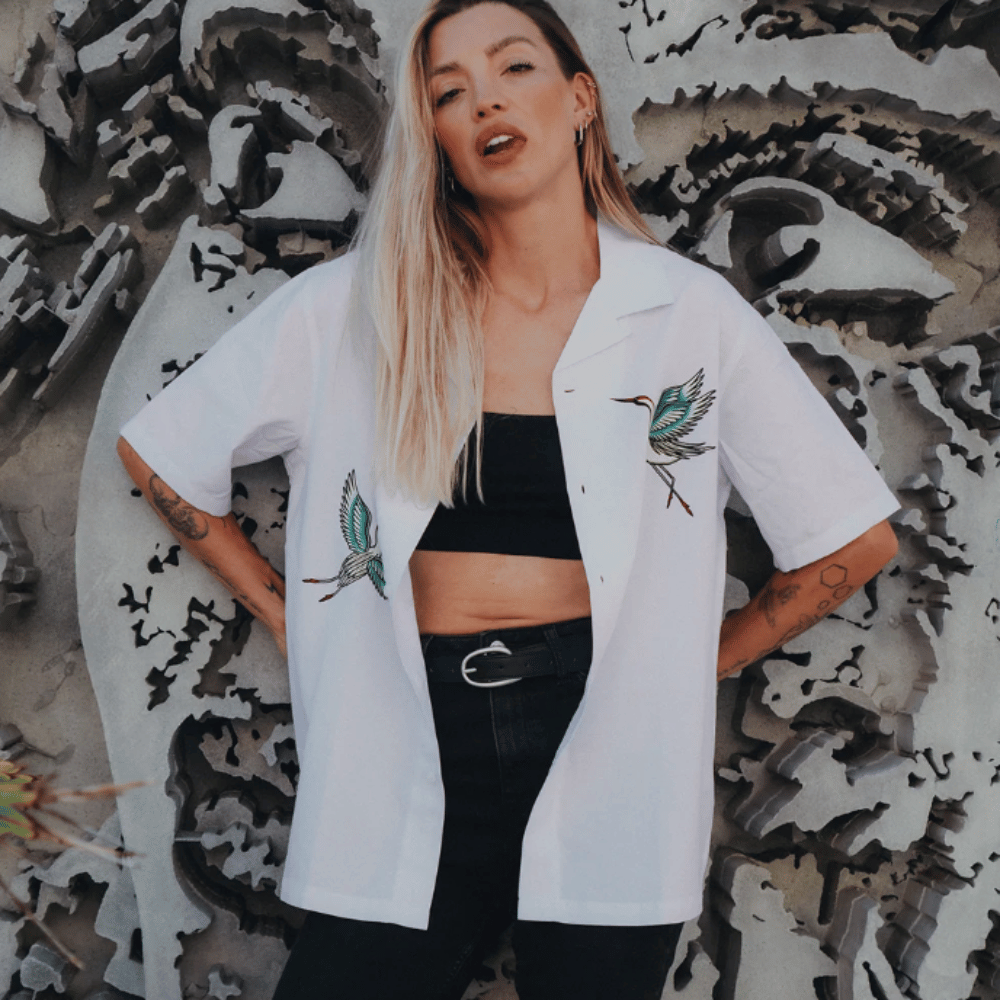Woman modelling the white Broken Society Cranes Havana Shirt with embroidered crane designs