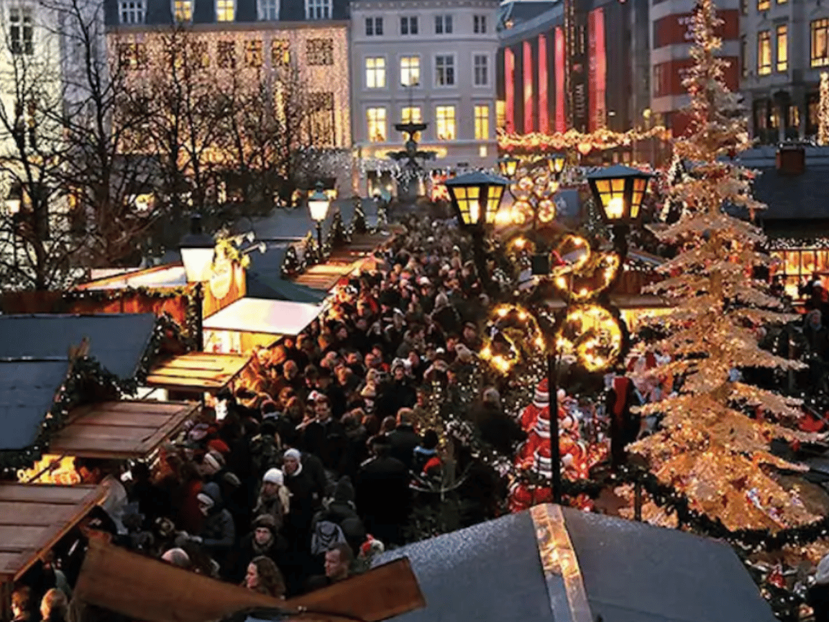 Festive Christmas market stalls and crowds at Hojbro Plads in Copenhagen.