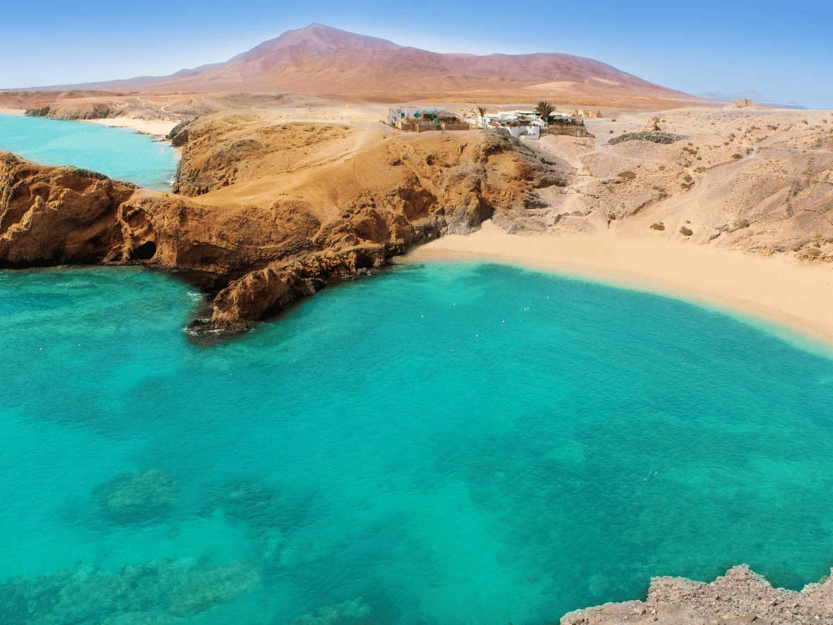 Turquoise bay surrounded by volcanic landscape in Lanzarote