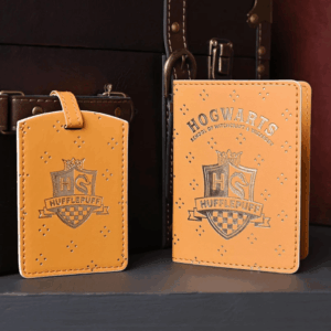 Yellow and gold Hufflepuff passport holder and luggage tag decorated with the Hogwarts crest and stars